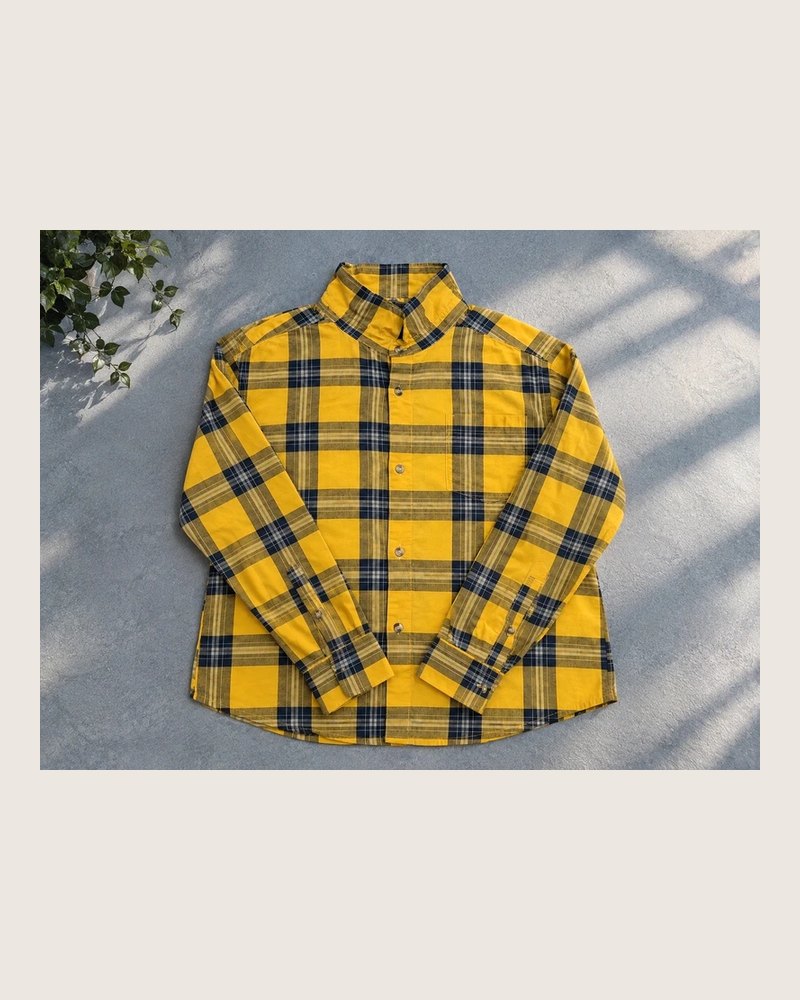 Chemise à carreaux jaune posée à plat